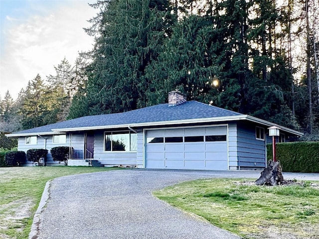 single story home featuring driveway, a chimney, roof with shingles, an attached garage, and a front lawn