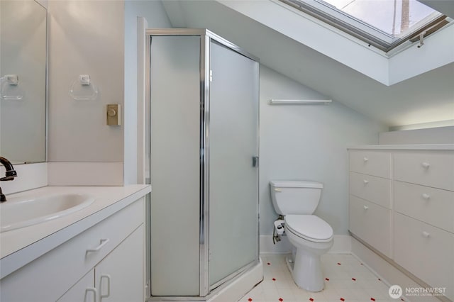 full bath featuring a shower stall, baseboards, toilet, vaulted ceiling with skylight, and vanity