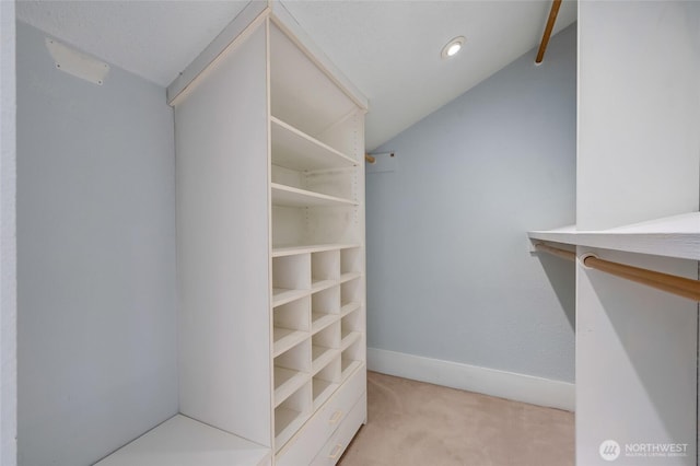 spacious closet featuring lofted ceiling and light carpet