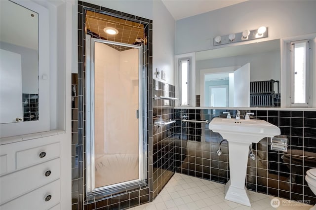 full bath with toilet, tile walls, and a shower stall