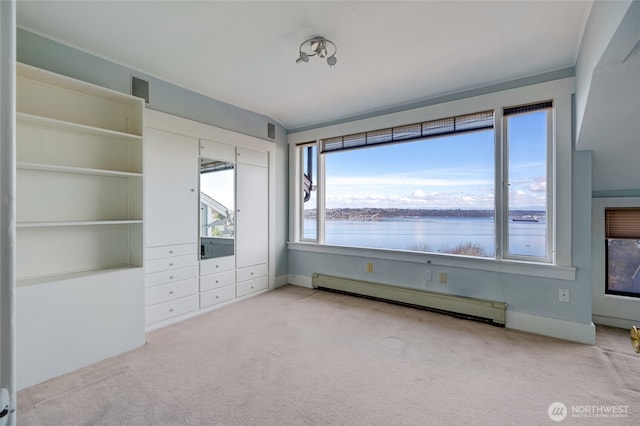 unfurnished bedroom featuring baseboard heating, carpet flooring, and a water view