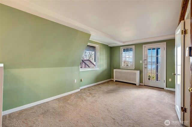 spare room with baseboards, carpet floors, and radiator