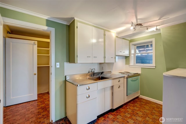 kitchen with crown molding, electric range oven, stainless steel counters, white cabinets, and a sink