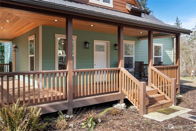 doorway to property with covered porch and metal roof