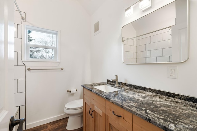 full bath featuring baseboards, visible vents, toilet, wood finished floors, and vanity