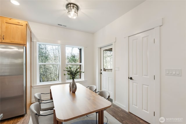 dining room featuring visible vents, dark wood finished floors, and baseboards