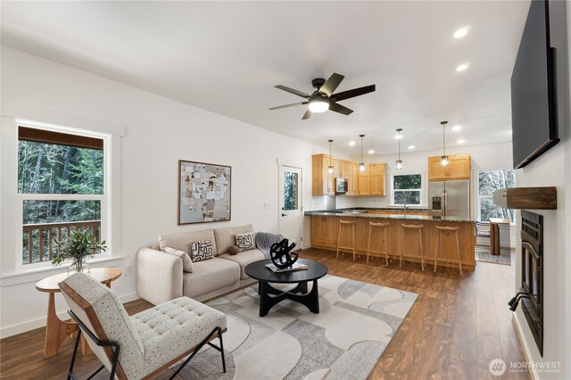 living area with recessed lighting, ceiling fan, baseboards, and wood finished floors