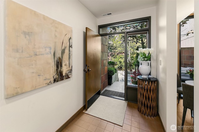 doorway featuring tile patterned flooring, visible vents, and baseboards