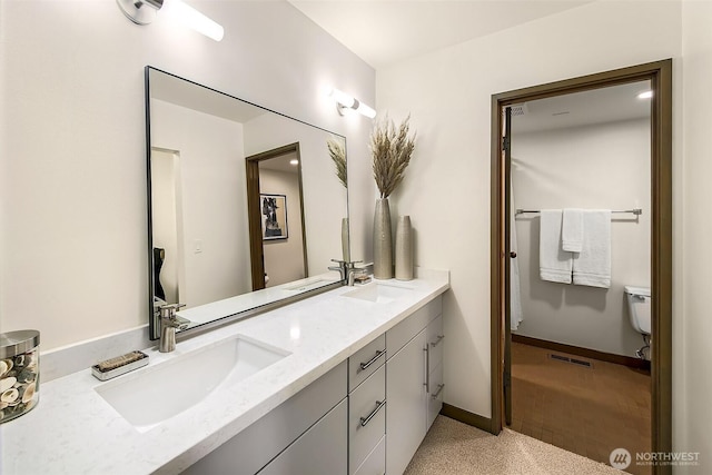 bathroom featuring visible vents, a sink, baseboards, and double vanity