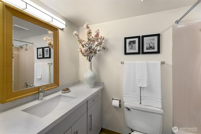 bathroom featuring toilet, curtained shower, visible vents, and vanity