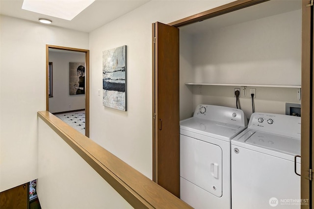 laundry room featuring washing machine and dryer, laundry area, and a skylight