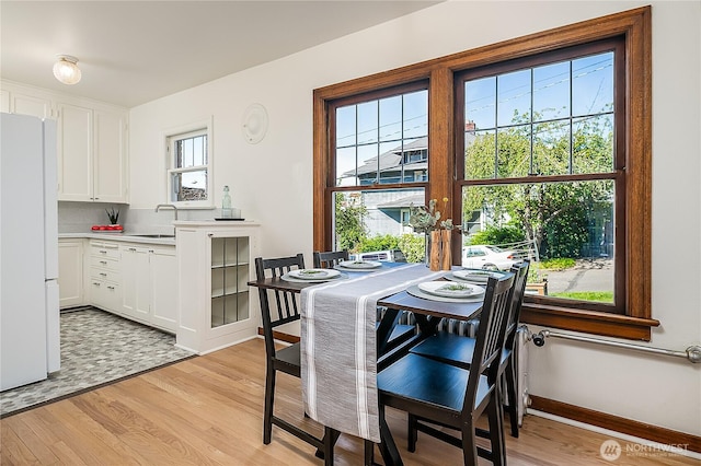 dining room featuring light wood-style flooring and baseboards