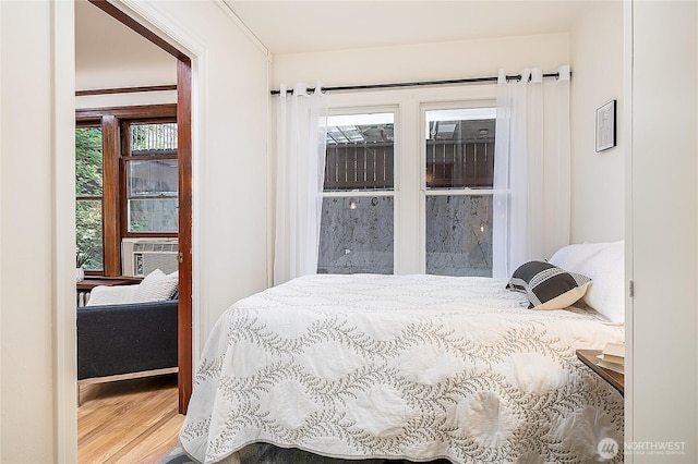 bedroom with cooling unit and wood finished floors