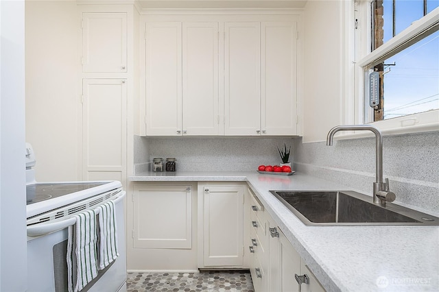 kitchen featuring white cabinets, light countertops, a sink, and electric range