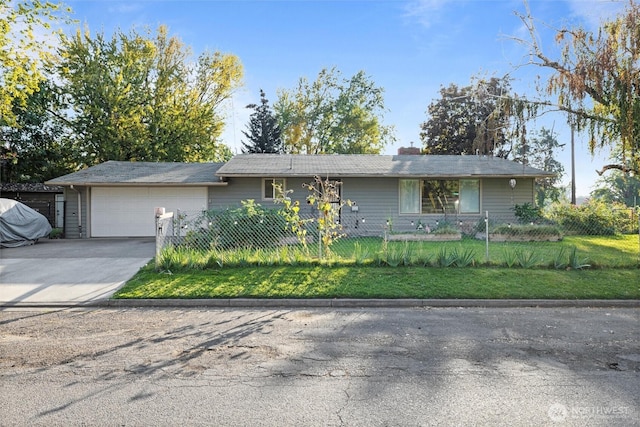 ranch-style home featuring a garage, driveway, and a fenced front yard