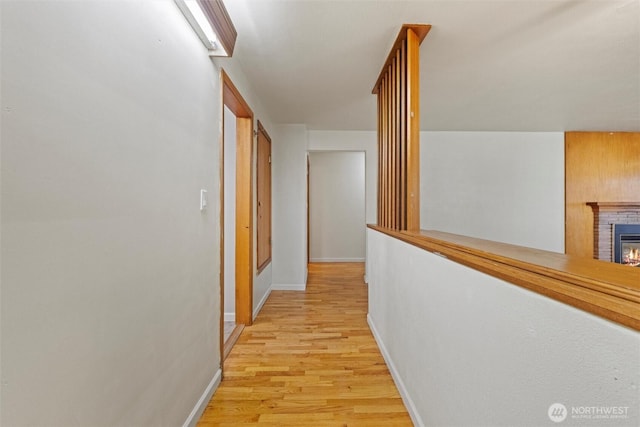 corridor featuring light wood-style flooring and baseboards