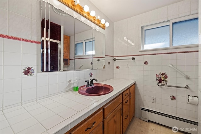 bathroom featuring baseboard heating, vanity, and tile walls