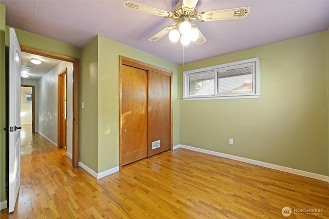 unfurnished bedroom featuring a closet, baseboards, ceiling fan, and light wood finished floors