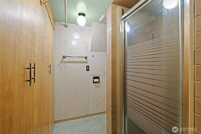 bathroom featuring a stall shower and visible vents