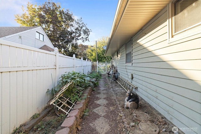 view of side of property with a fenced backyard and a garden