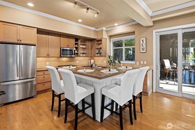dining space featuring ornamental molding, track lighting, and light wood-style floors