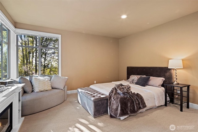 carpeted bedroom with a glass covered fireplace, recessed lighting, multiple windows, and baseboards