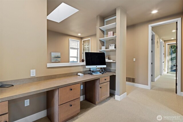office area featuring light carpet, built in study area, recessed lighting, visible vents, and a skylight