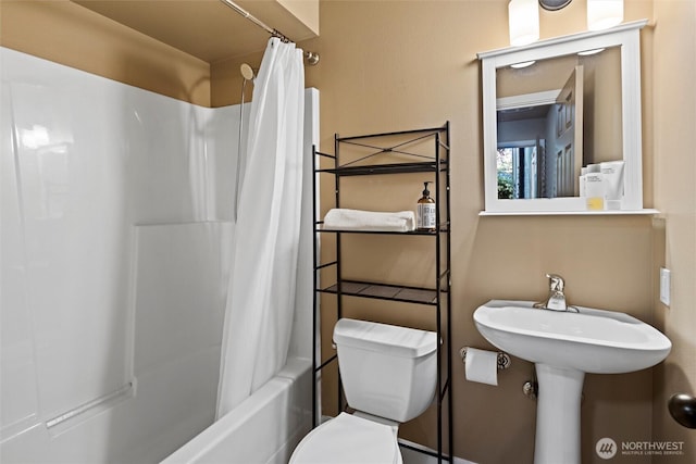 bathroom featuring shower / tub combo and toilet