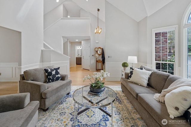 living room with a decorative wall, recessed lighting, a wainscoted wall, and light wood finished floors