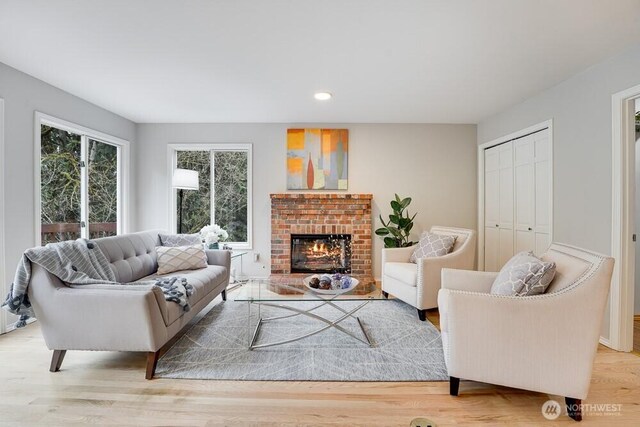 living area featuring a brick fireplace and light wood finished floors