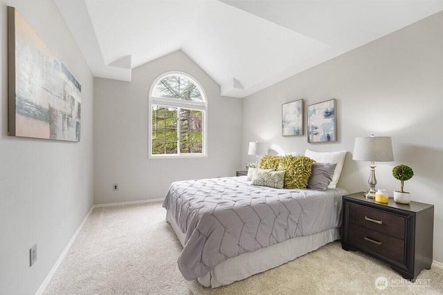 bedroom with vaulted ceiling, light colored carpet, and baseboards