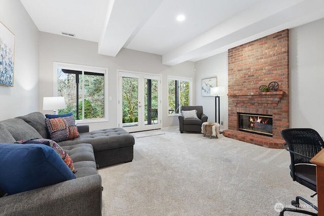 living area with french doors, beam ceiling, a healthy amount of sunlight, and a fireplace