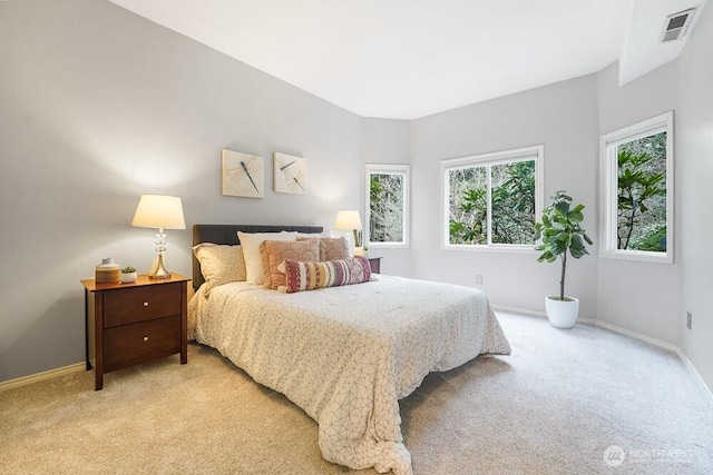 bedroom with light colored carpet, visible vents, and baseboards