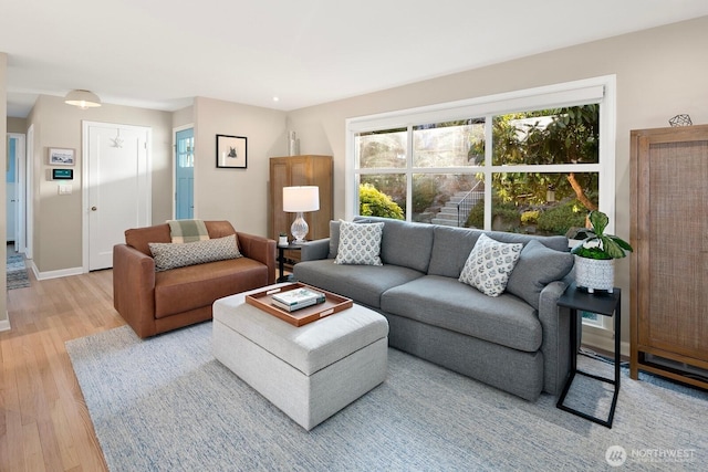 living area with light wood-style flooring and baseboards