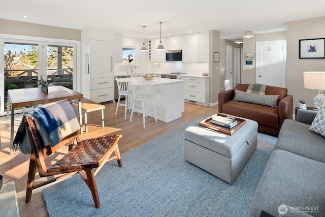 living room with light wood-style flooring and recessed lighting