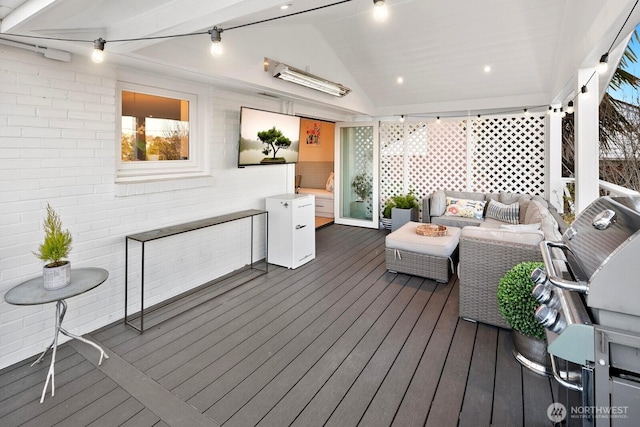 wooden terrace with an outdoor living space with a fire pit