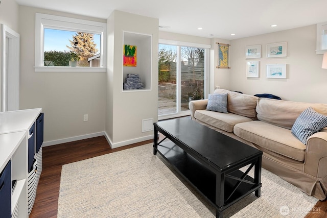 living room featuring dark wood-type flooring, recessed lighting, and baseboards