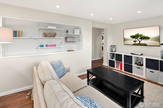 living room with stacked washer / dryer, recessed lighting, baseboards, and wood finished floors