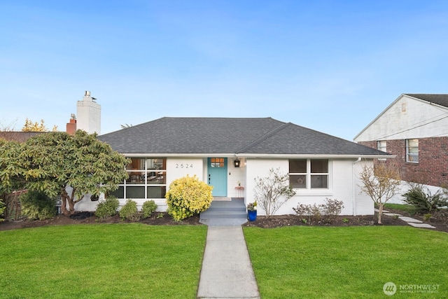 ranch-style house featuring a shingled roof, a chimney, and a front yard