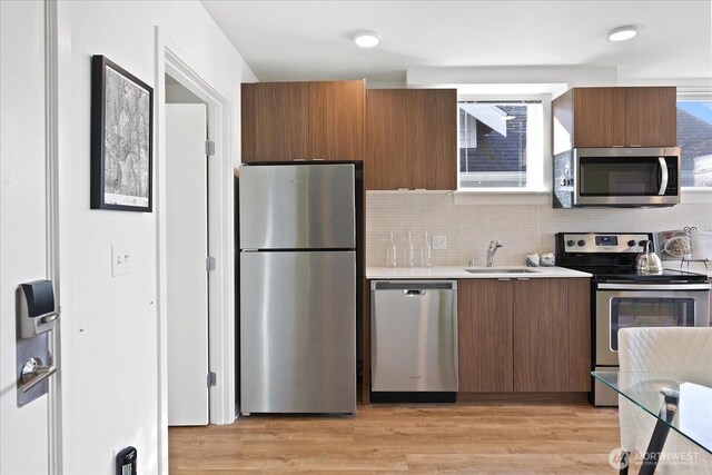 kitchen featuring a sink, light countertops, modern cabinets, and stainless steel appliances