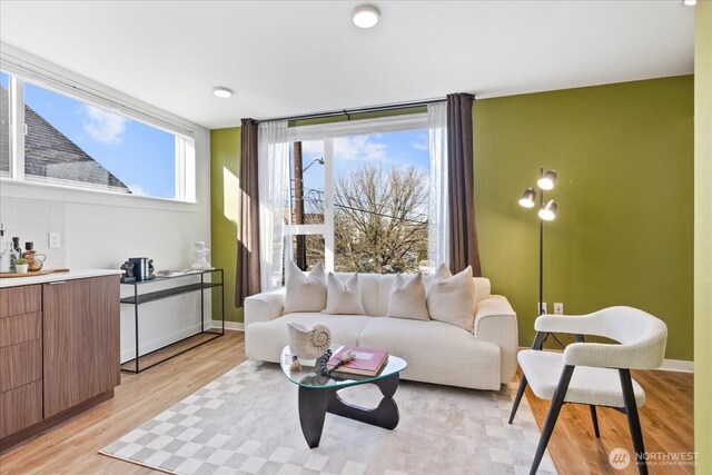 living area with light wood finished floors and baseboards