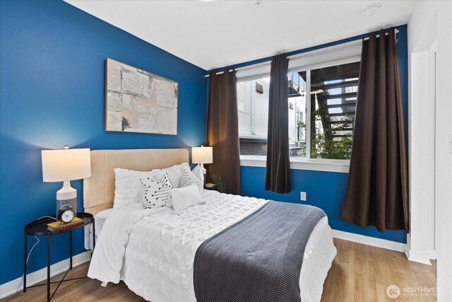 bedroom featuring wood finished floors and baseboards