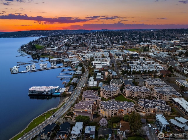 aerial view at dusk featuring a water view