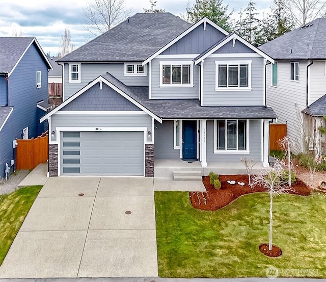 craftsman-style home featuring a front yard, fence, covered porch, a garage, and board and batten siding