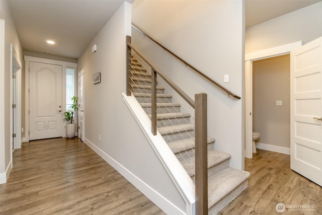 stairs featuring recessed lighting, wood finished floors, and baseboards