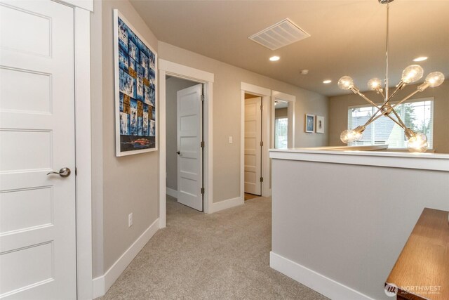 corridor with visible vents, baseboards, a chandelier, light carpet, and recessed lighting