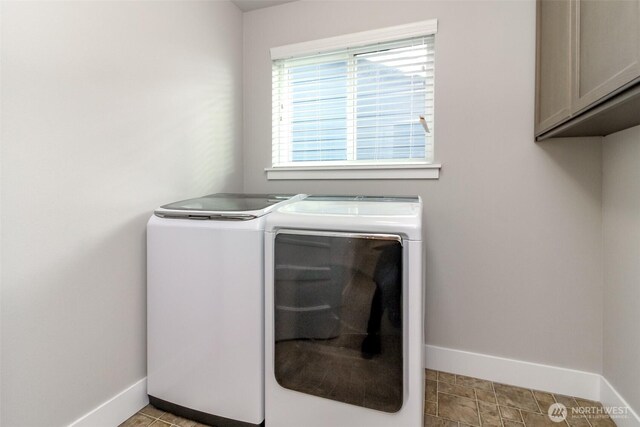 laundry area with baseboards, cabinet space, and independent washer and dryer