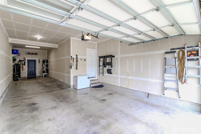 garage featuring white refrigerator and a garage door opener