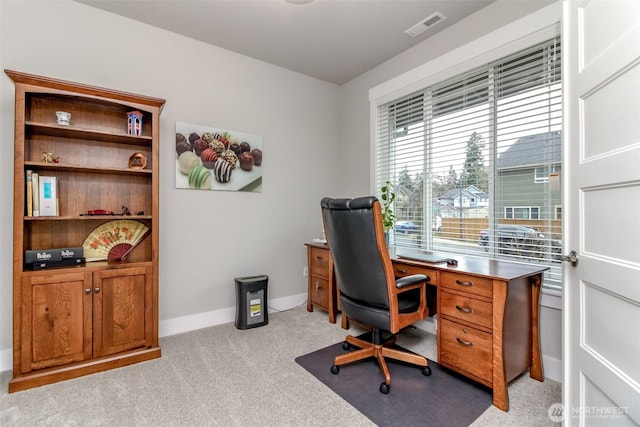 office area featuring light carpet, visible vents, and baseboards