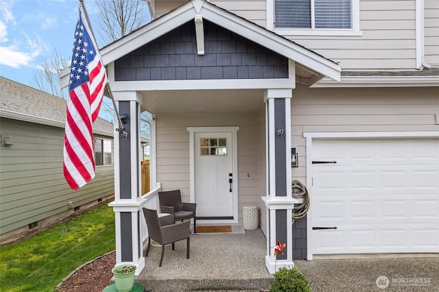 entrance to property featuring covered porch and an attached garage